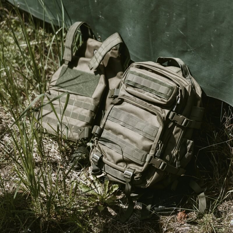 Mochilas tácticas y chaleco sobre lona de camuflaje